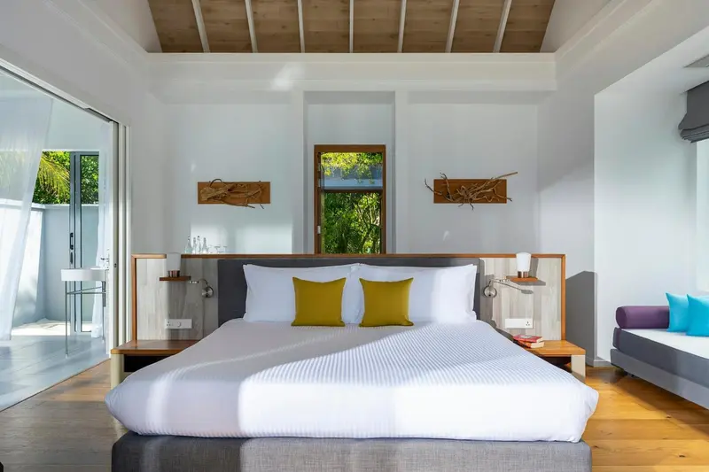 Une chambre lumineuse avec un grand lit et un canapé.