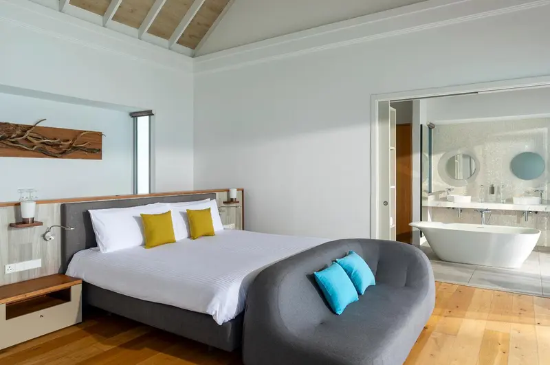 Une chambre lumineuse avec un grand lit et un espace détente.