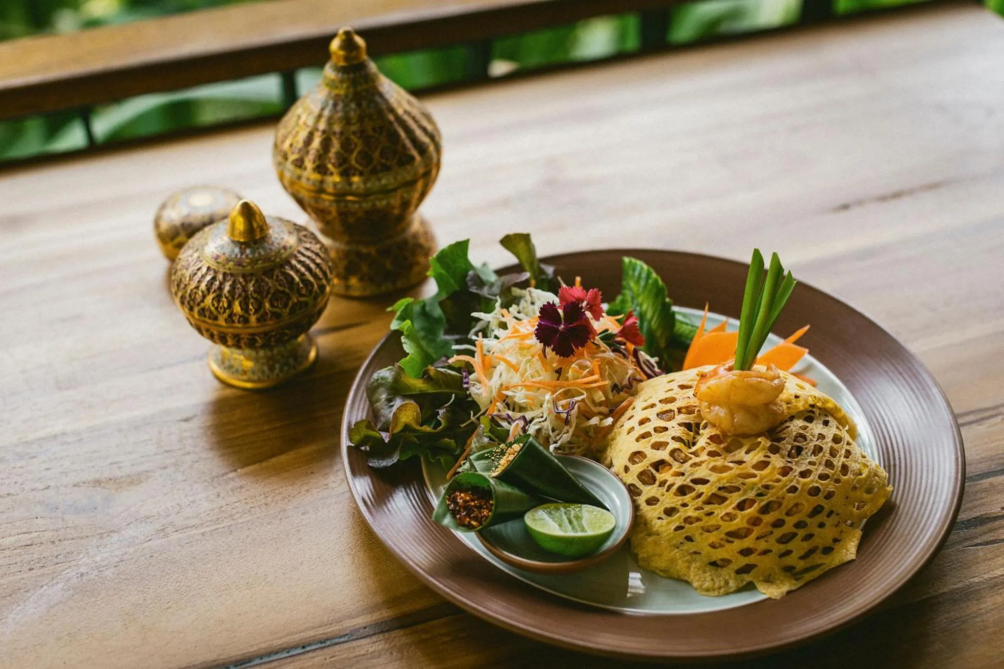 Assiette décorée avec une préparation culinaire et des éléments végétaux.