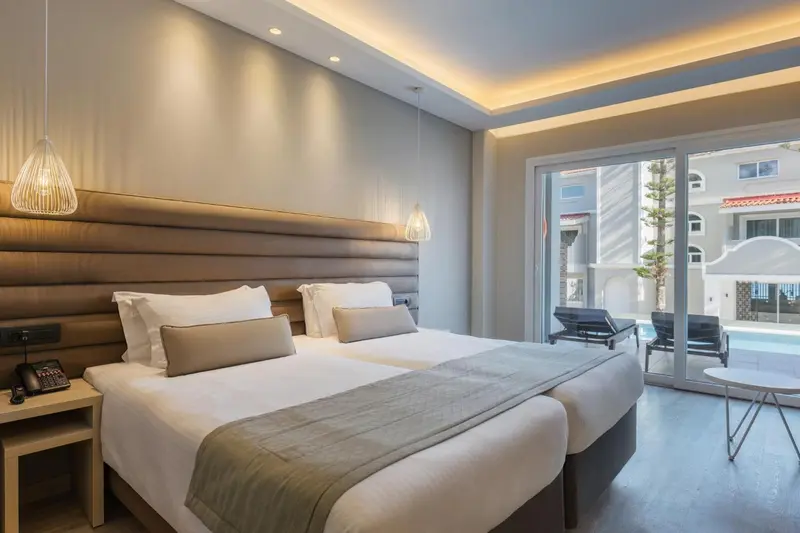 Une chambre lumineuse avec un grand lit et un accès à une terrasse.