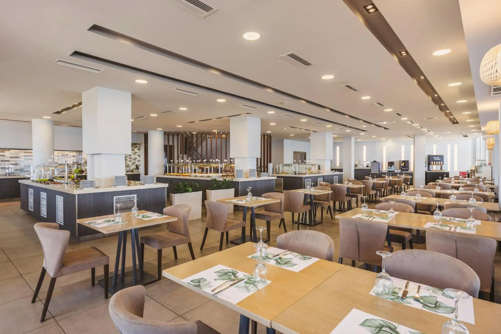 Une salle lumineuse avec des tables dressées pour un repas.