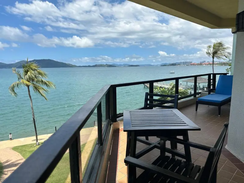 Vue d'un balcon avec mobilier donnant sur la mer et des îles.