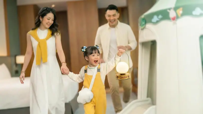 Une famille se promène dans un intérieur lumineux et décoré.