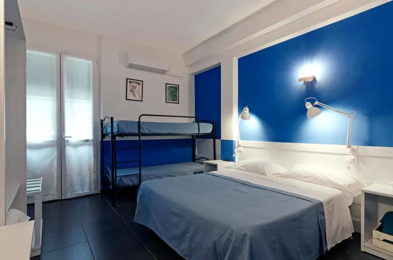 Une chambre avec un lit superposé et un lit simple.