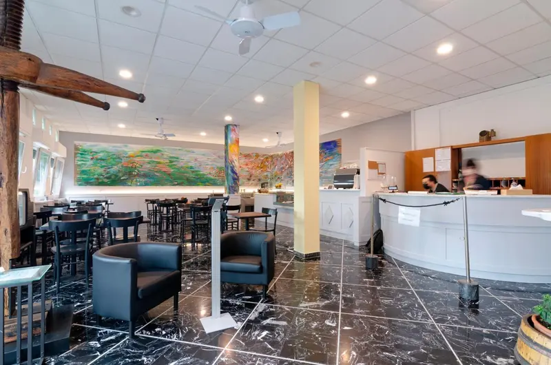 Espace intérieur lumineux avec comptoir d'accueil et mobilier contemporain.