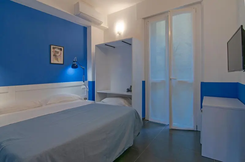 Une chambre lumineuse avec un lit et un accès à une terrasse.