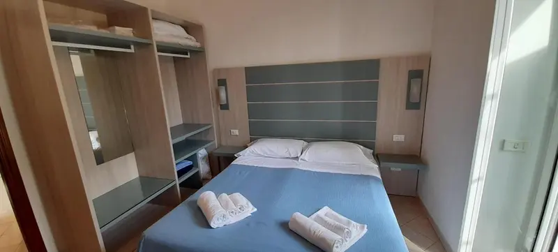 Une chambre avec un grand lit recouvert d'une couverture bleue et des oreillers blancs.