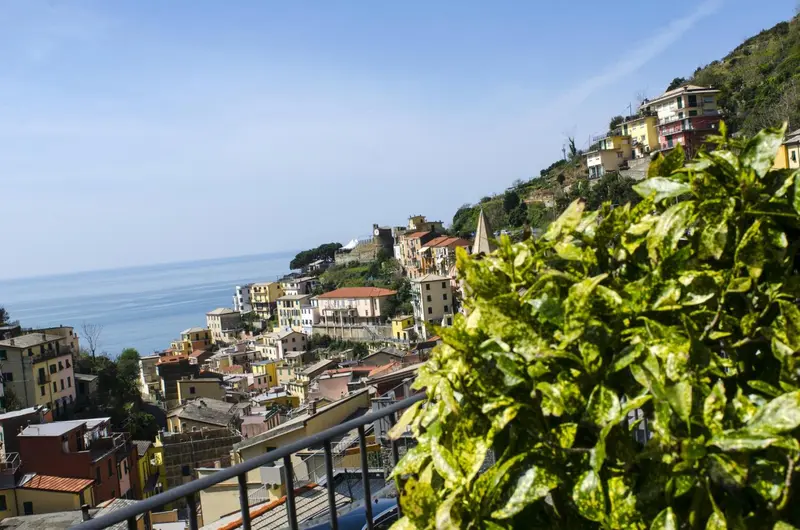 Vue panoramique sur un village coloré surplombant la mer.
