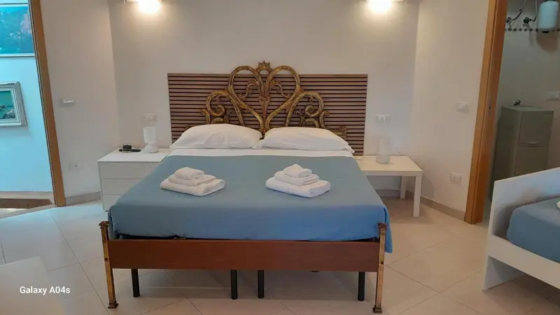 Une chambre lumineuse avec un grand lit recouvert d'une courtepointe bleue.