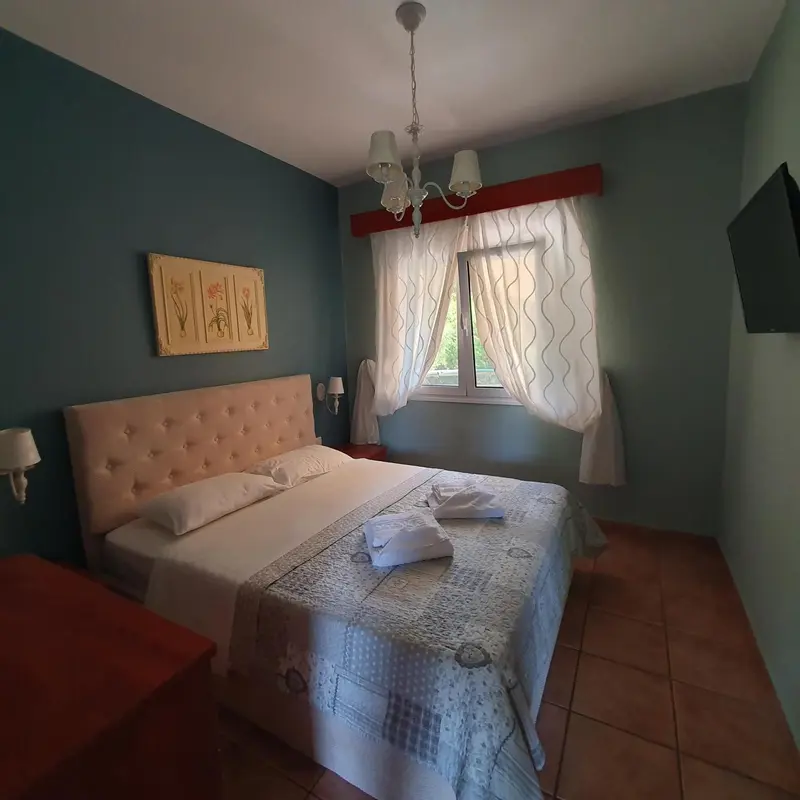 Une chambre lumineuse avec un grand lit recouvert d'une courtepointe.