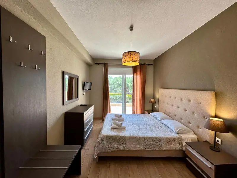 Une chambre lumineuse avec un grand lit et un accès à une terrasse.