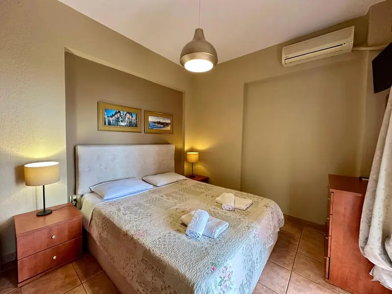 Une chambre lumineuse avec un grand lit recouvert d'une courtepointe florale.