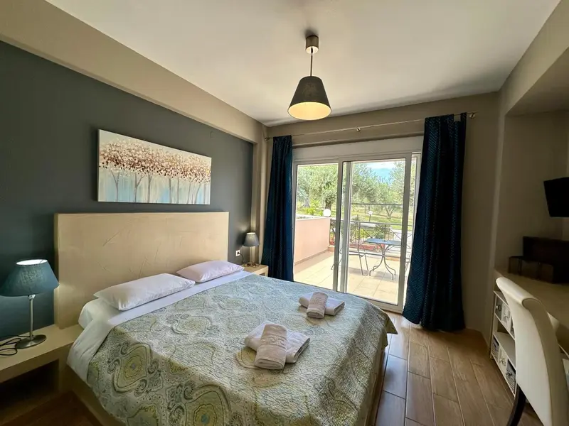 Une chambre lumineuse avec un grand lit et un accès à une terrasse.
