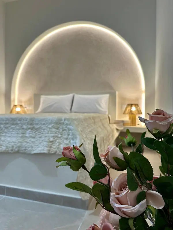 Une chambre à coucher lumineuse avec un grand lit et une décoration florale.