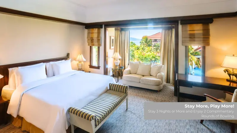 Une chambre lumineuse avec un grand lit et un coin salon.
