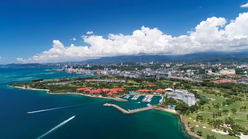 Vue aérienne d'une côte avec des bâtiments et une marina.