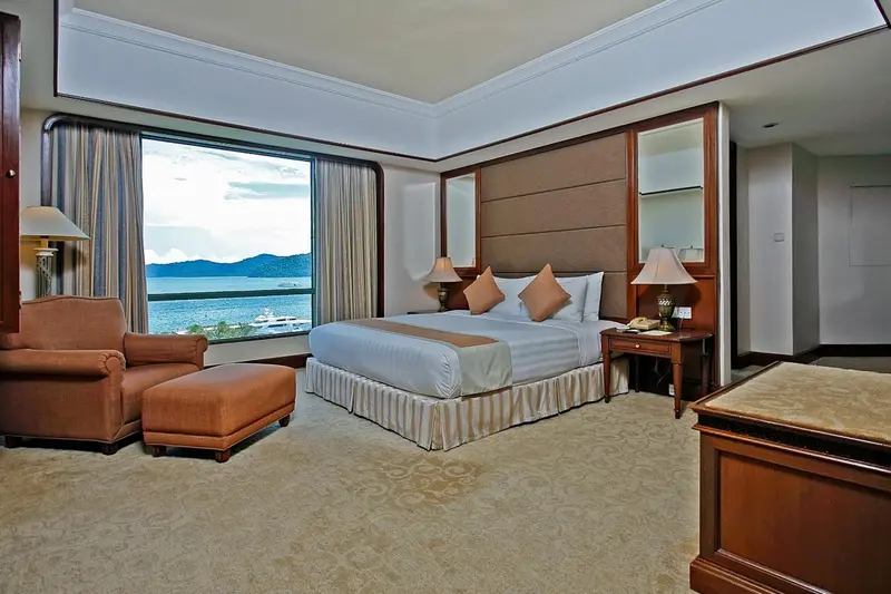 Une chambre lumineuse avec un grand lit et une vue sur la mer.