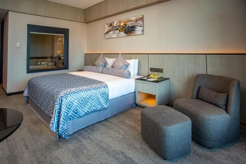 Une chambre d'hotel moderne avec un grand lit et un fauteuil.