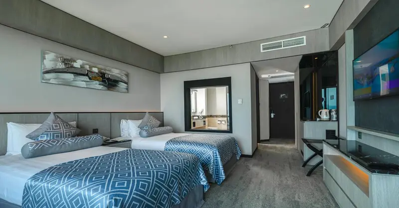 Chambre moderne avec deux lits simples et décoration sobre.