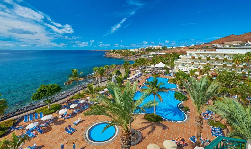 Vue aérienne d'un complexe hôtelier avec piscine et accès à la mer.