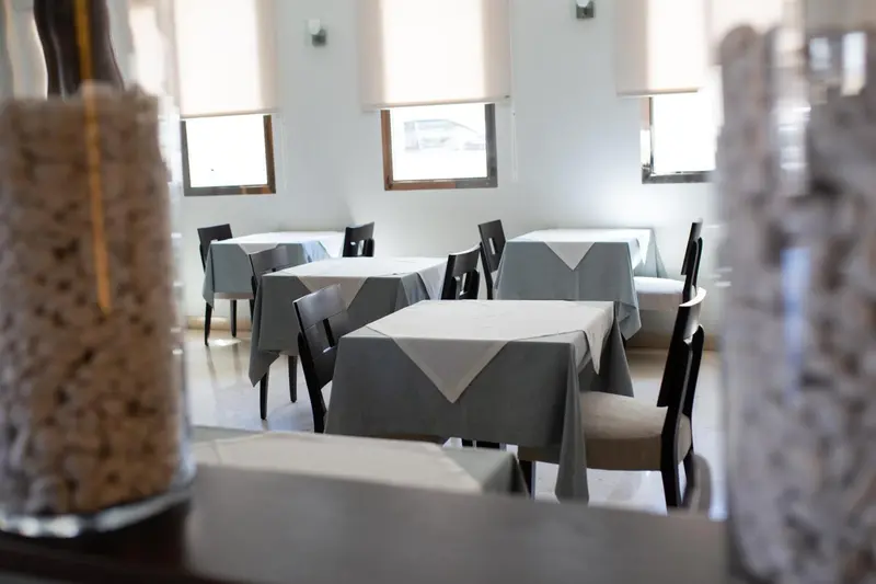 Une salle lumineuse avec des tables dressées pour le repas.