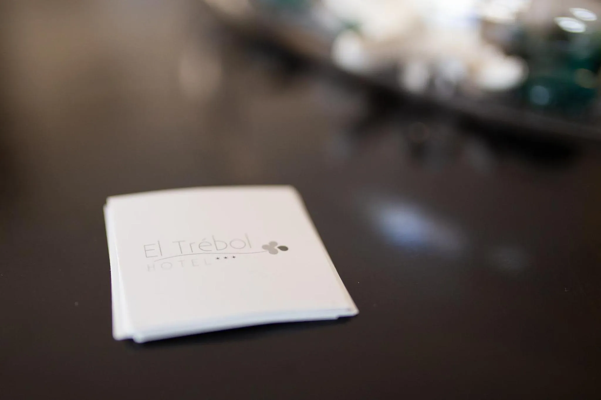 Une carte d'hôtel blanche repose sur une surface sombre.