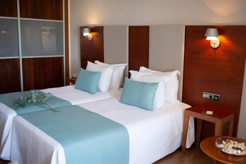 Une chambre lumineuse avec deux lits simples et une décoration sobre.