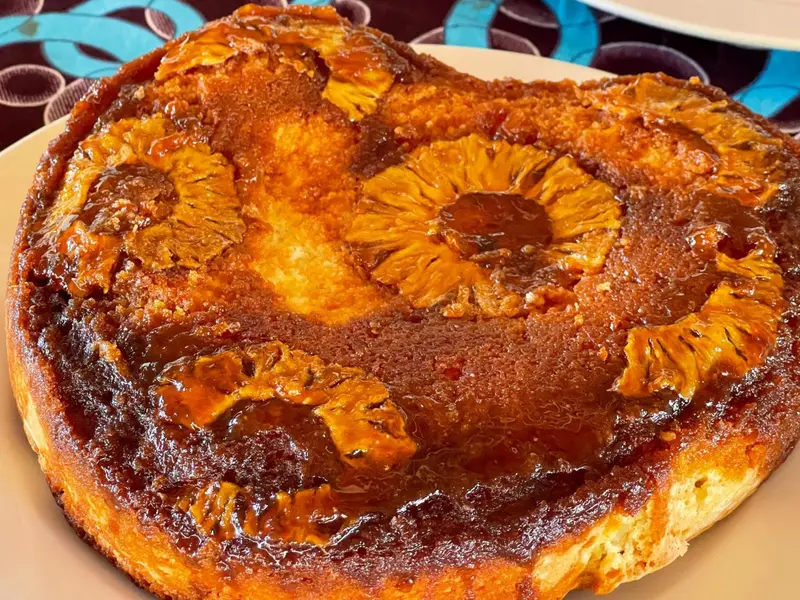 Un gâteau renversé à l'ananas caramélisé est présenté sur une assiette.