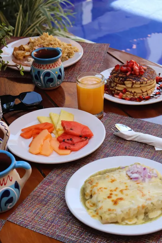 Une table est dressée avec plusieurs assiettes de nourriture et des boissons.