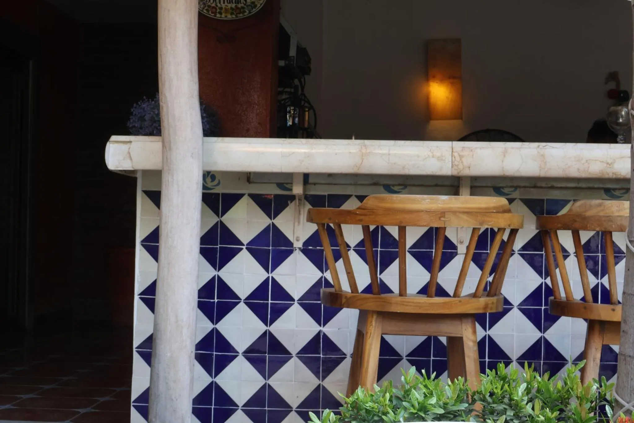 Un comptoir de bar en extérieur avec deux tabourets en bois.