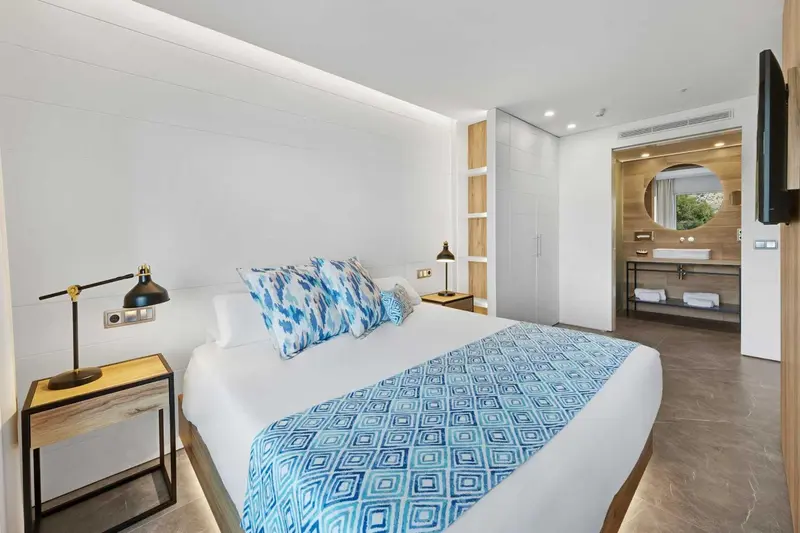 Une chambre lumineuse avec un grand lit recouvert d'une couette à motifs.