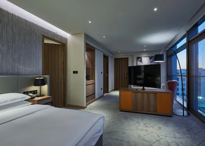 Une chambre d'hôtel moderne avec un grand lit et un téléviseur.