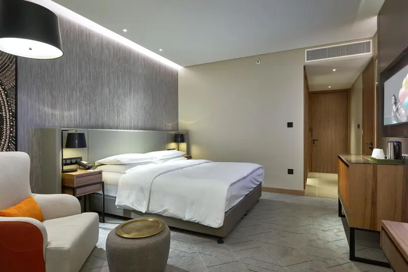 Une chambre moderne avec un grand lit et un fauteuil.