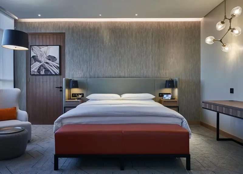 Une chambre moderne avec un grand lit et un fauteuil.