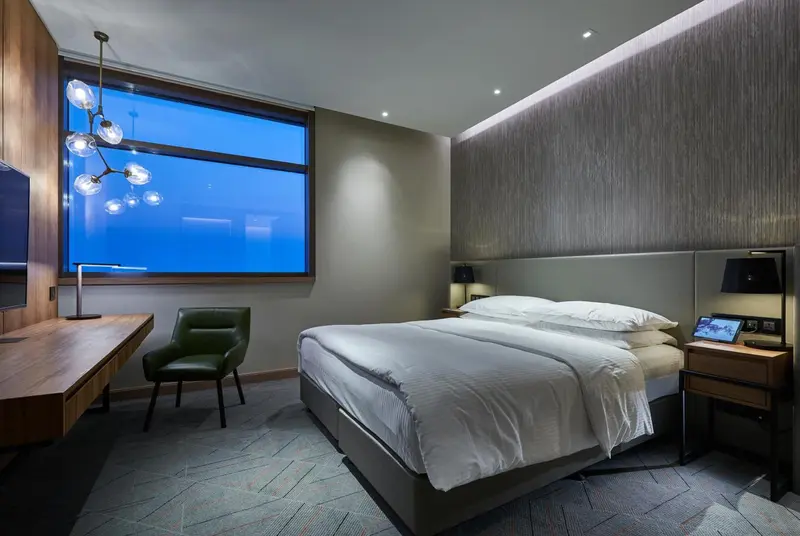 Une chambre moderne avec un grand lit et un bureau.