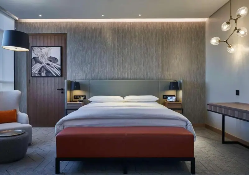 Une chambre moderne avec un grand lit et un fauteuil.