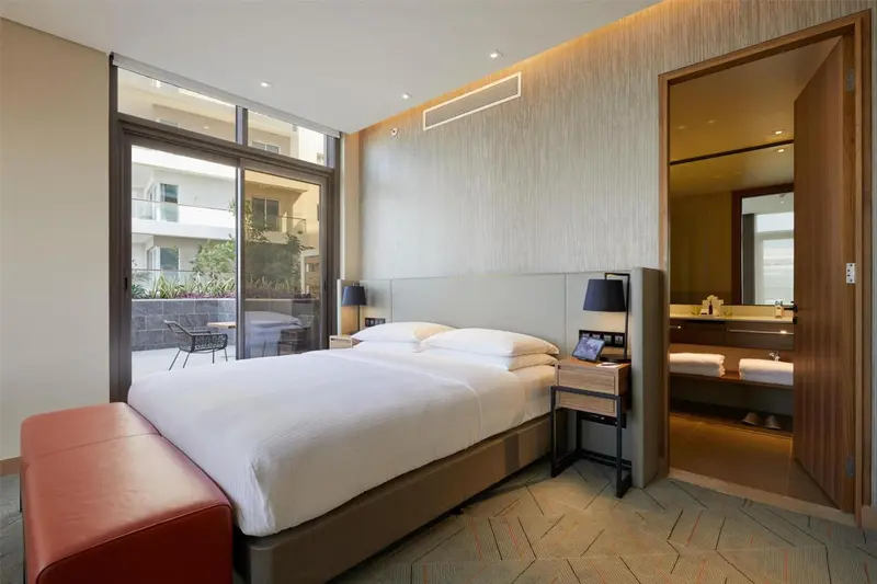 Une chambre lumineuse avec un grand lit et un accès à une terrasse.