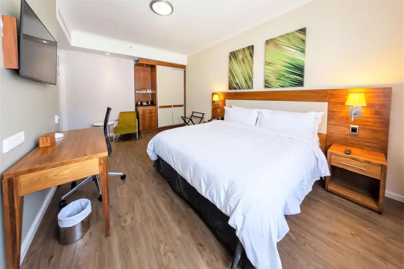 Une chambre lumineuse avec un grand lit et un espace bureau.