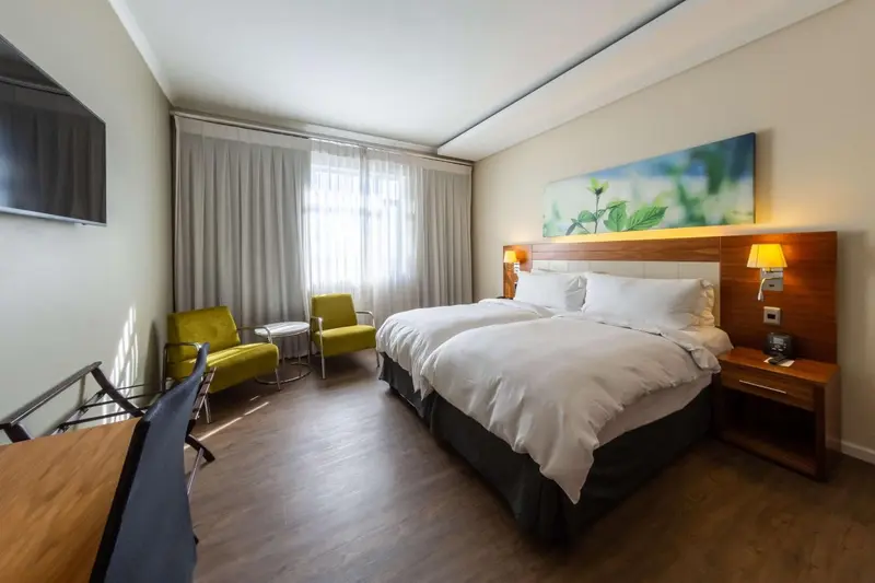 Une chambre lumineuse avec un grand lit et un coin salon.