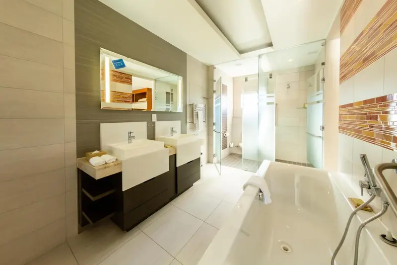 Une salle de bain moderne avec deux vasques et une baignoire.