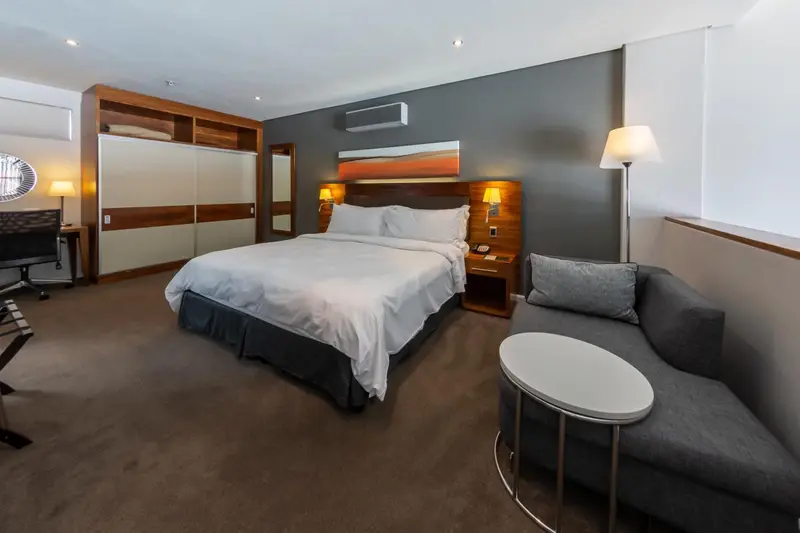 Une chambre d'hôtel moderne avec un grand lit et un coin salon.