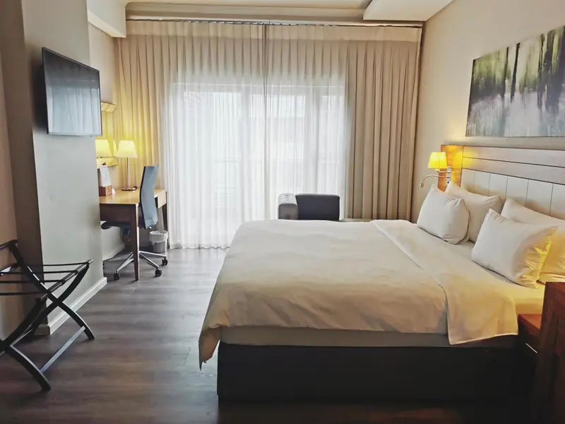 Une chambre d'hôtel lumineuse avec un grand lit et un espace de travail.