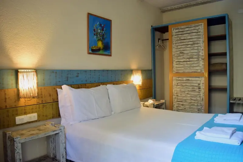 Une chambre lumineuse avec un lit double et une décoration colorée.