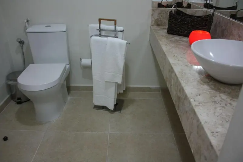 Une salle de bain moderne avec des équipements sanitaires blancs et un plan de travail en marbre.