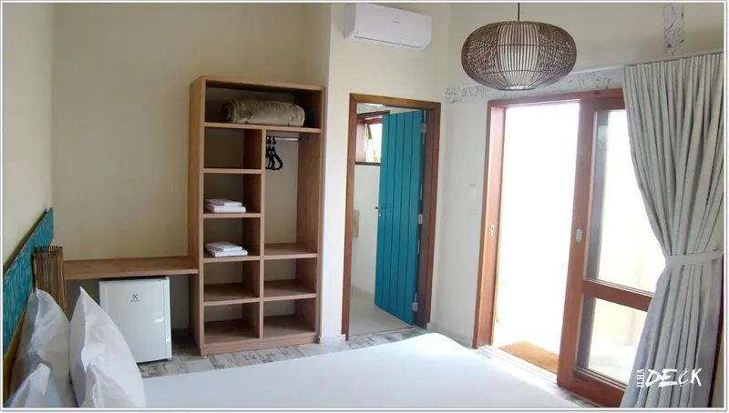 Une chambre lumineuse avec un lit et un meuble de rangement.