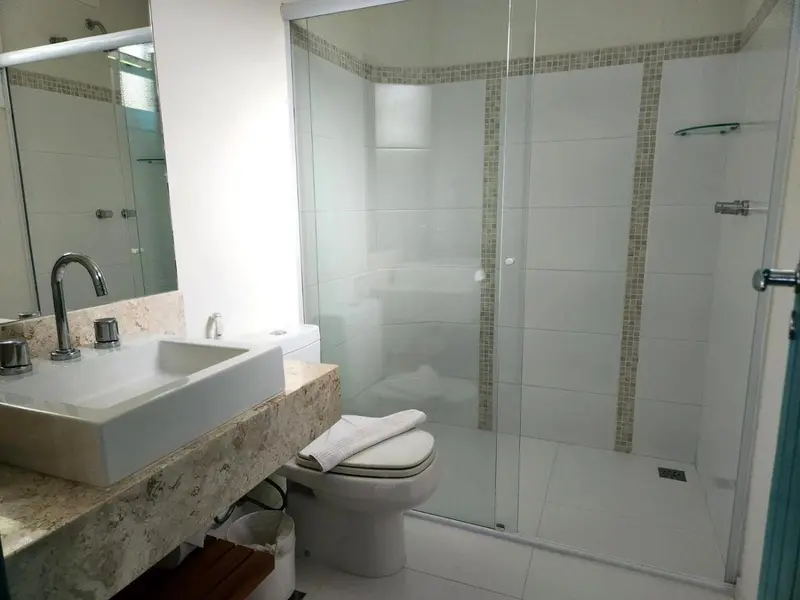 Une salle de bain claire avec douche à l'italienne et lavabo.