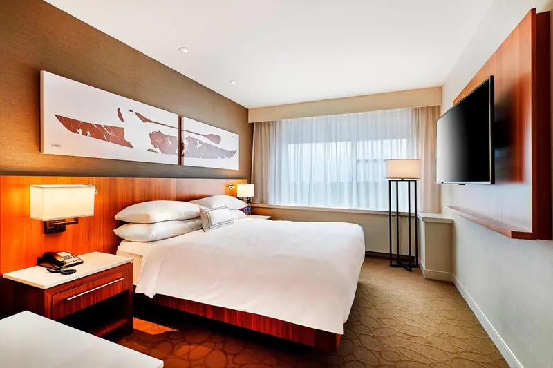 Chambre d'hôtel moderne avec un grand lit et des œuvres d'art au mur.