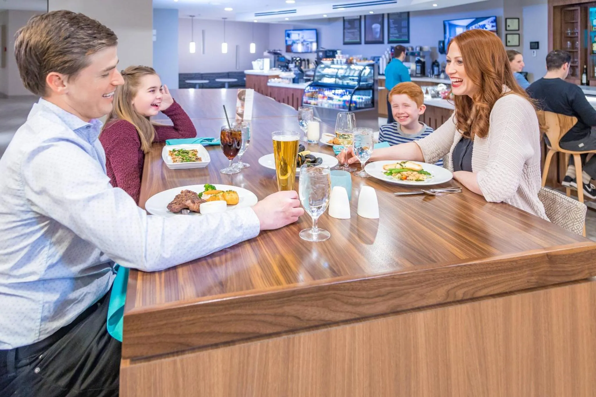 Une famille est assise autour d'une table dans un espace de restauration.
