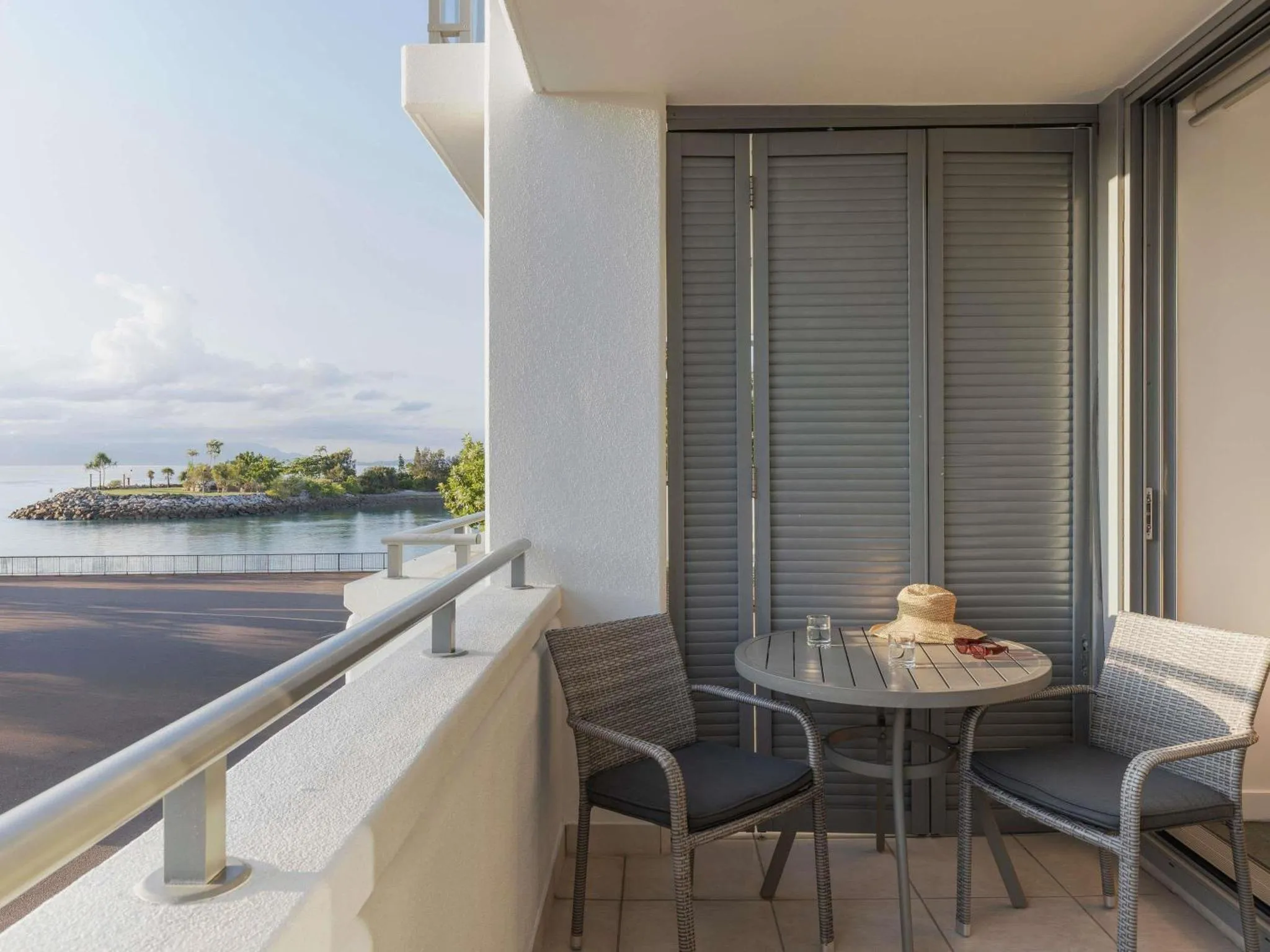 Une terrasse avec une table et des chaises offre une vue sur la mer.