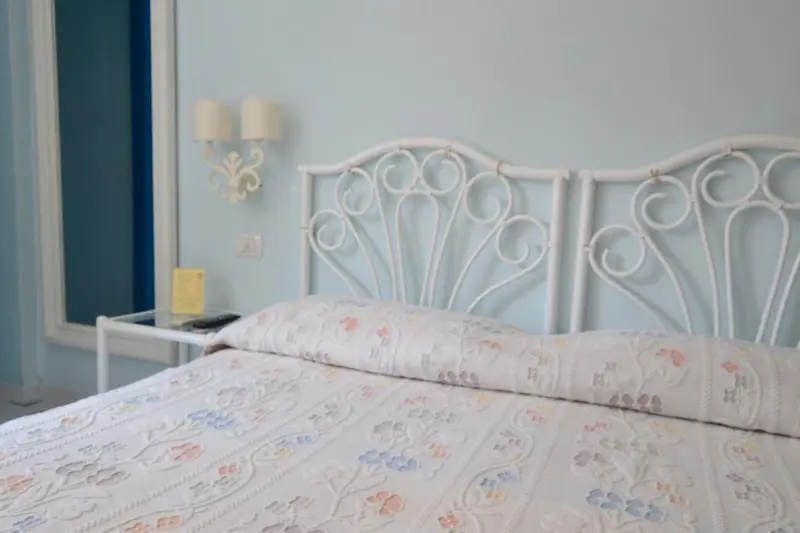 Une chambre lumineuse avec un lit recouvert d'une couette fleurie.